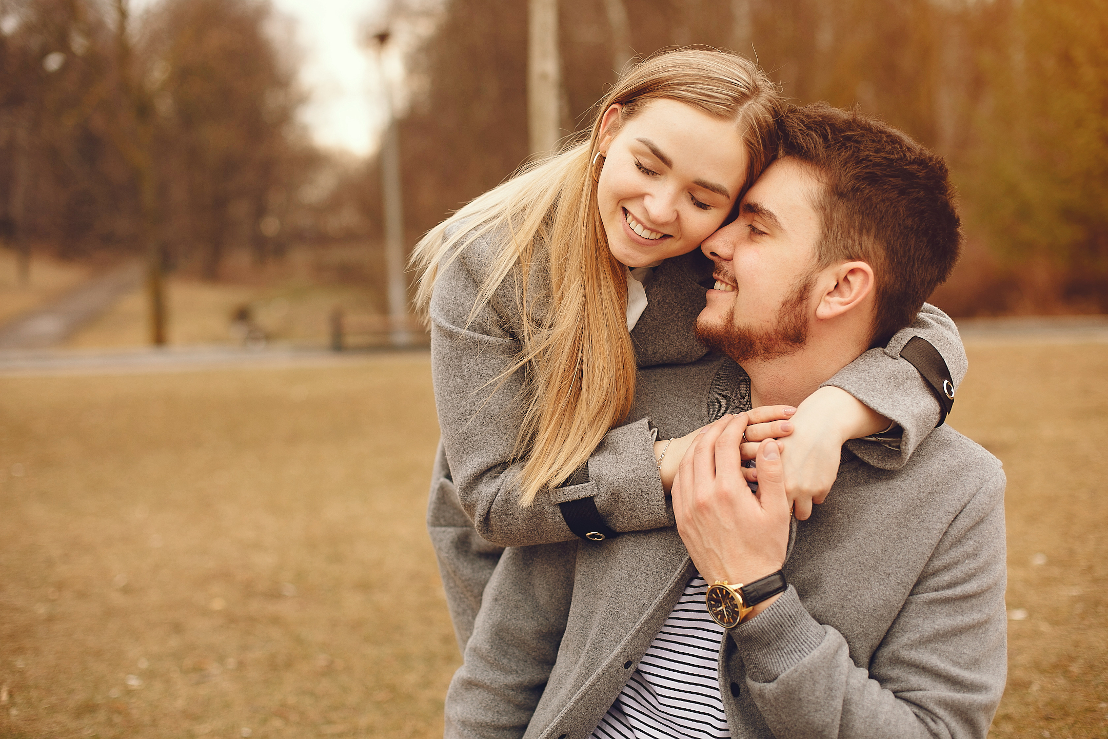 Beautiful young couple embrace in autumn park